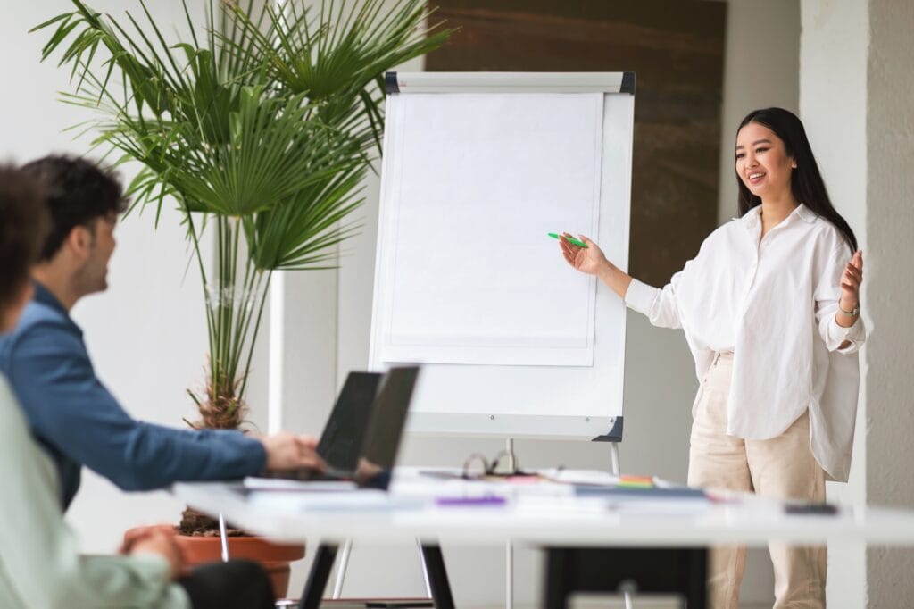 Поиск методик привлечения инвестиций 2 Asian Businesswoman Pitching Startup Idea To Coworkers In Modern Office