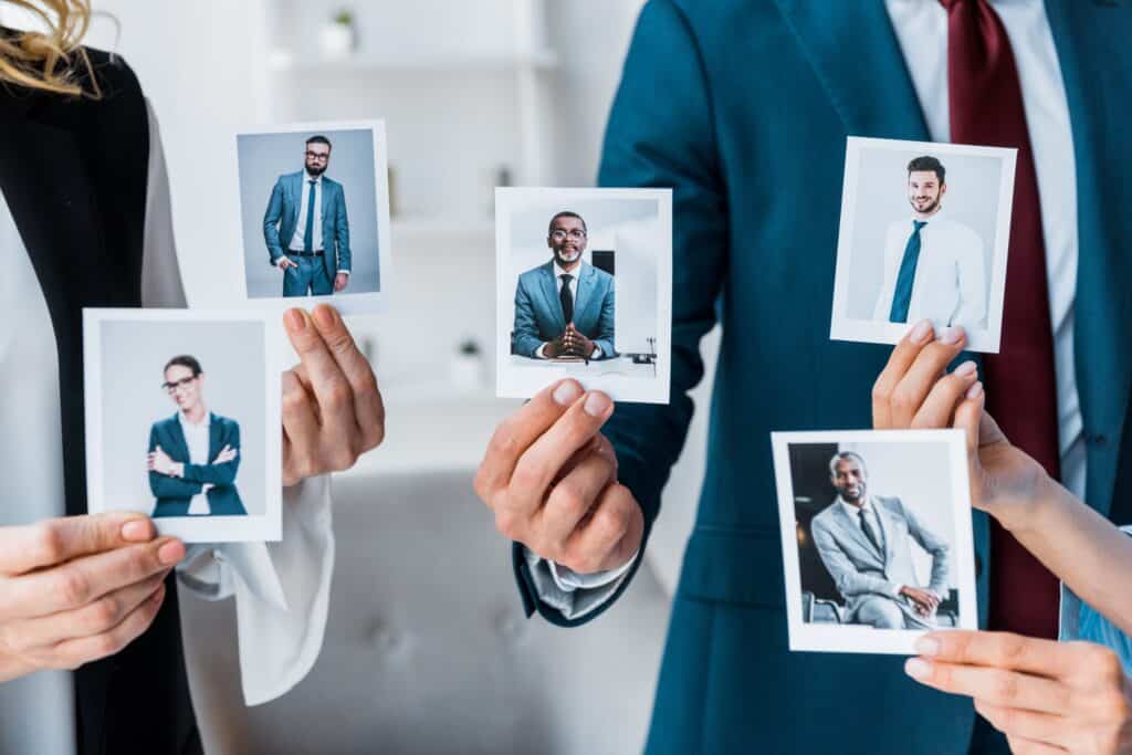 Эффективный поиск персонала 2 cropped view of recruiters touching photos while standing in office