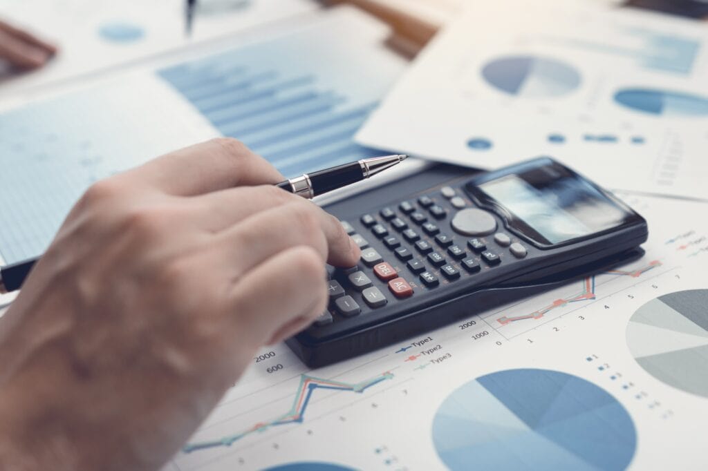hand investors are using calculators to calculate the company's earnings to invest