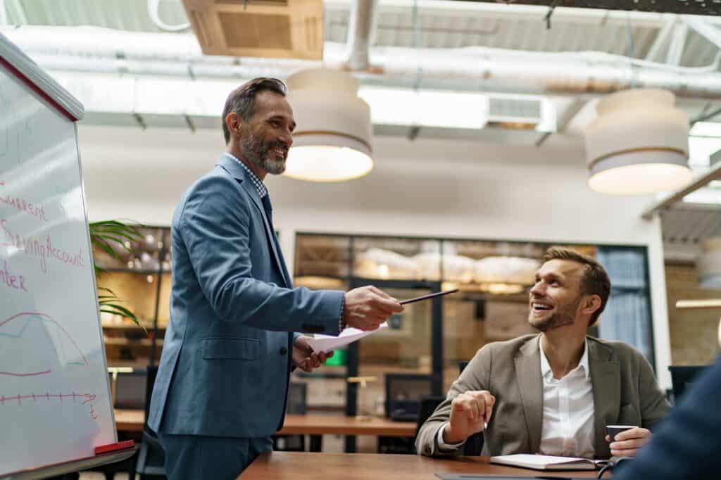 Условия выступления в бизнес-клубе Casemeeting 1 Mature business coach or speaker make flip chart presentation to diverse businesspeople at meeting