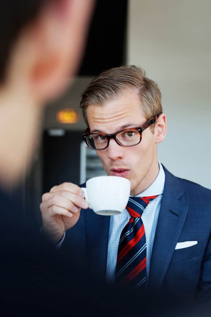 Вечерняя бизнес-встреча резидентов клуба 3 Young businessman drinking coffee with coworker at cafe during meeting